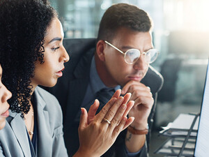 IT team looks at charts on monitor
