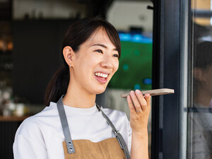 Woman uses phone voice command in cafe