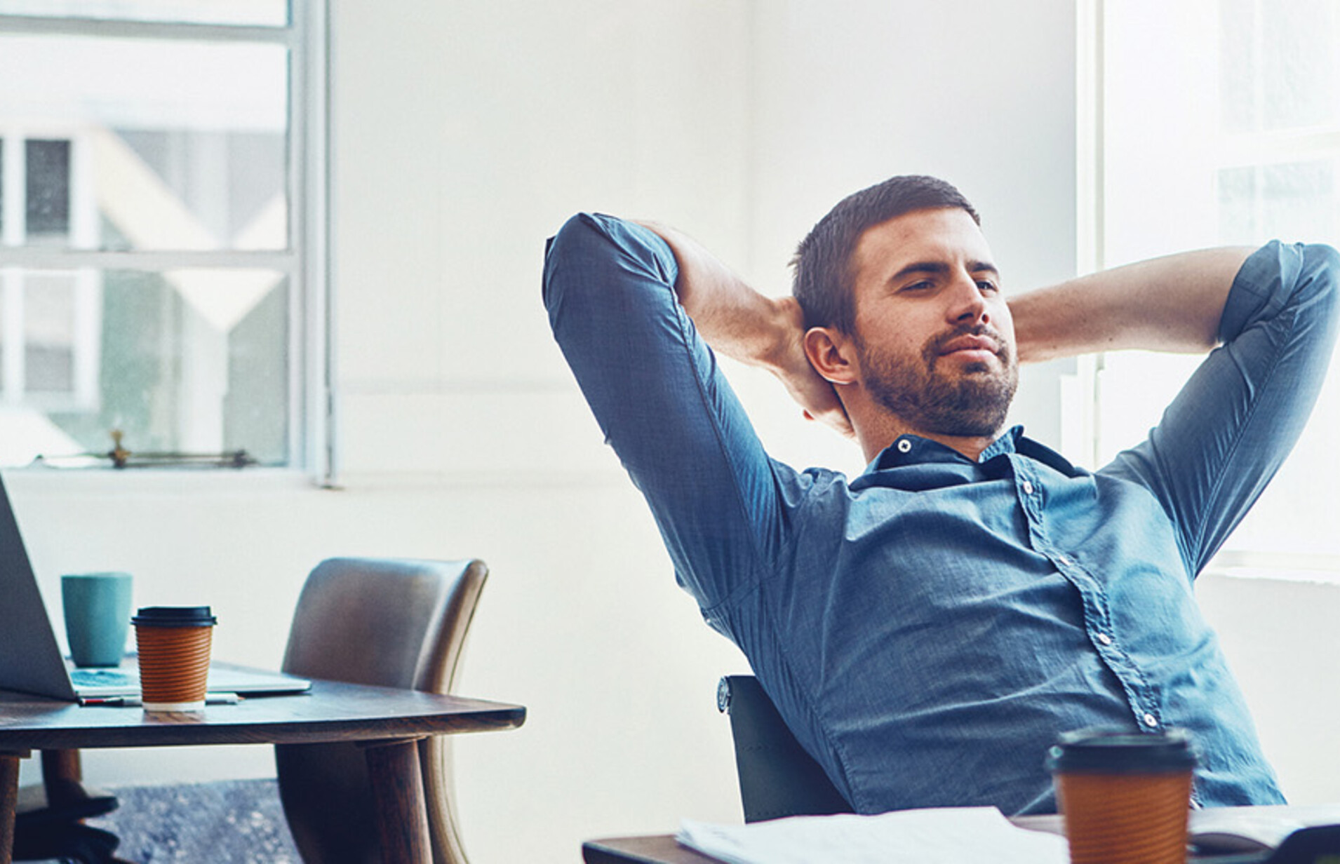 An employee leans back at his desk