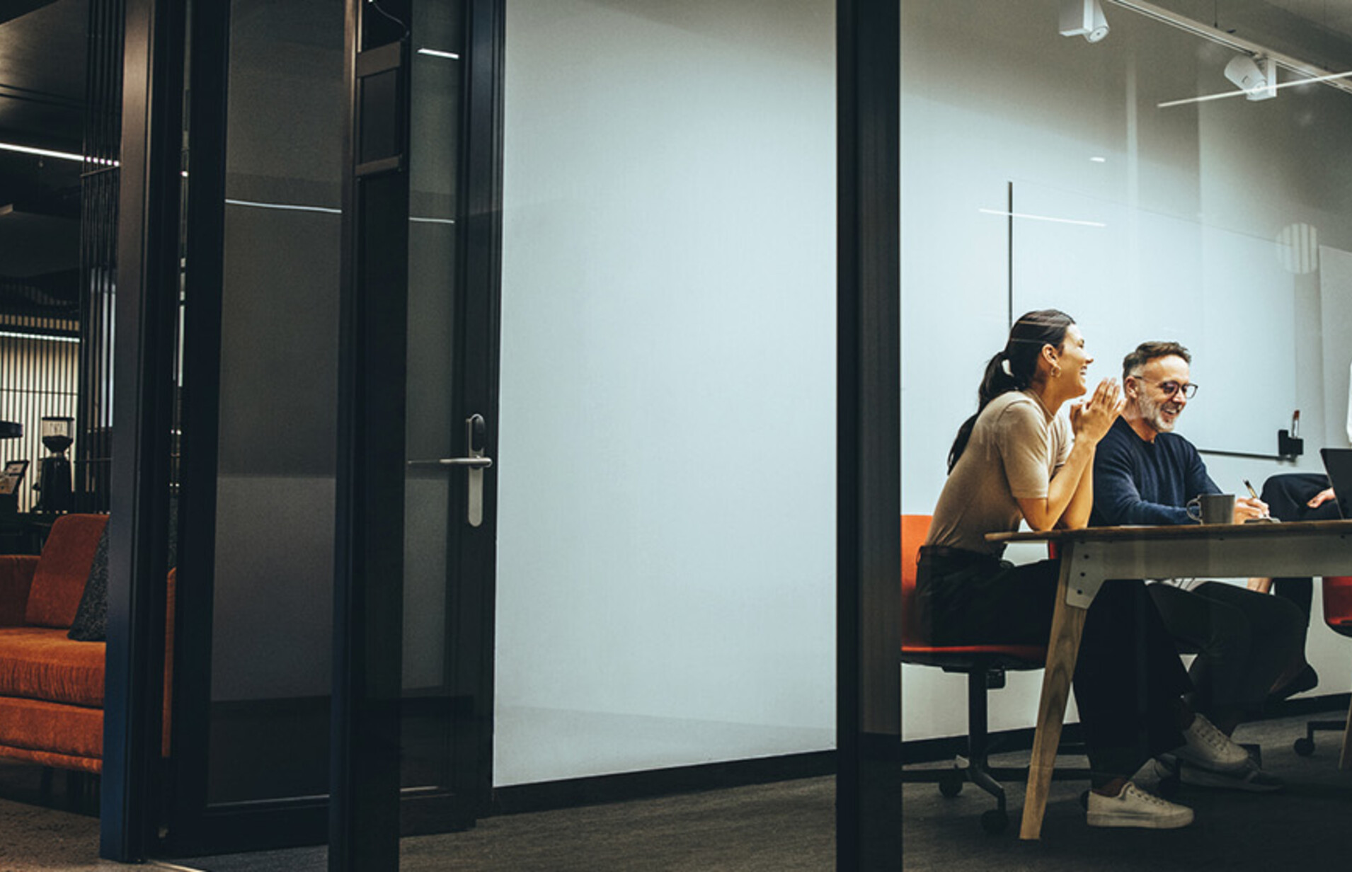 A group of employees gather in a meeting room