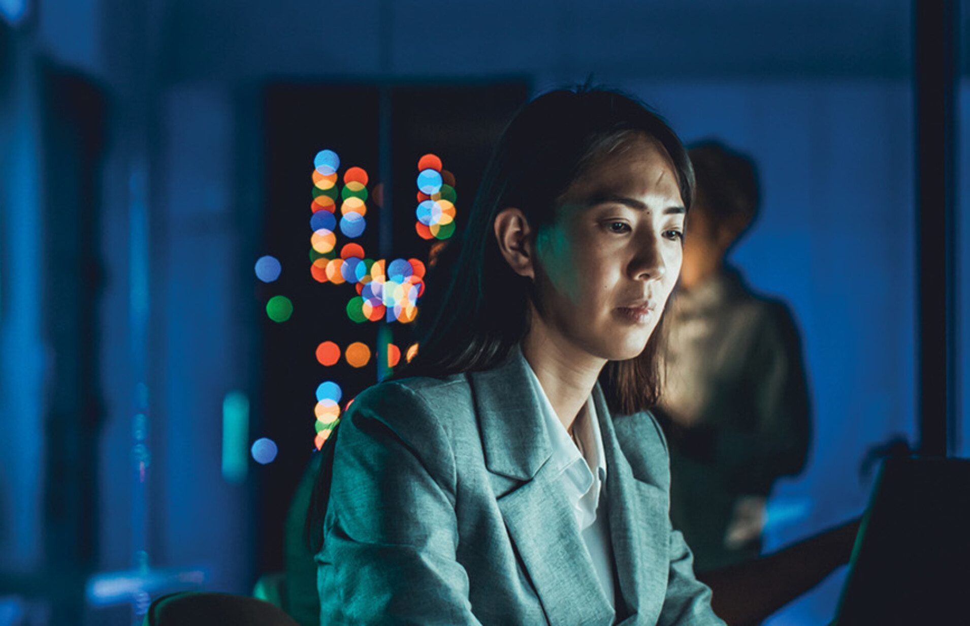 IT specialist working on a laptop in low lighting