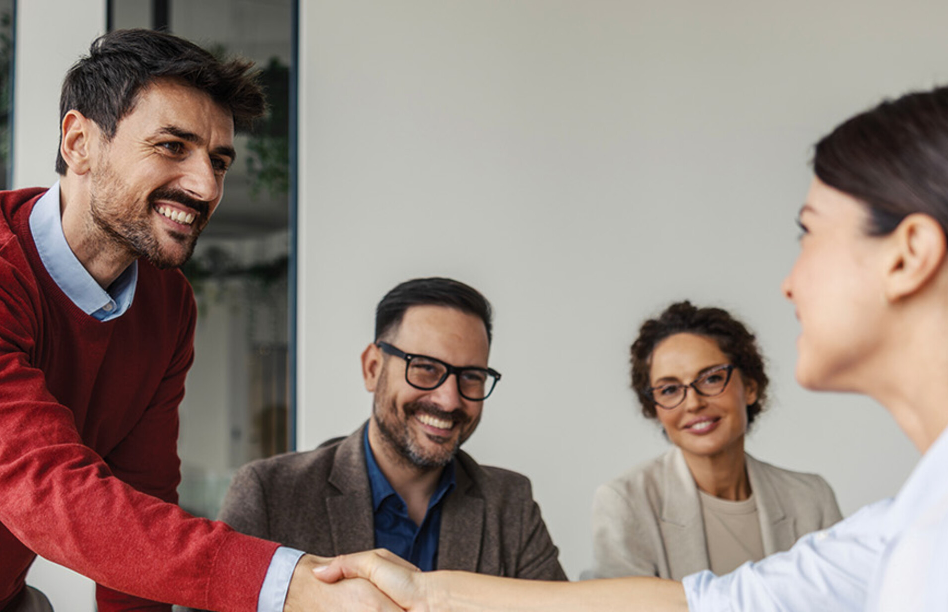 Colleagues shaking hands in an office business meeting