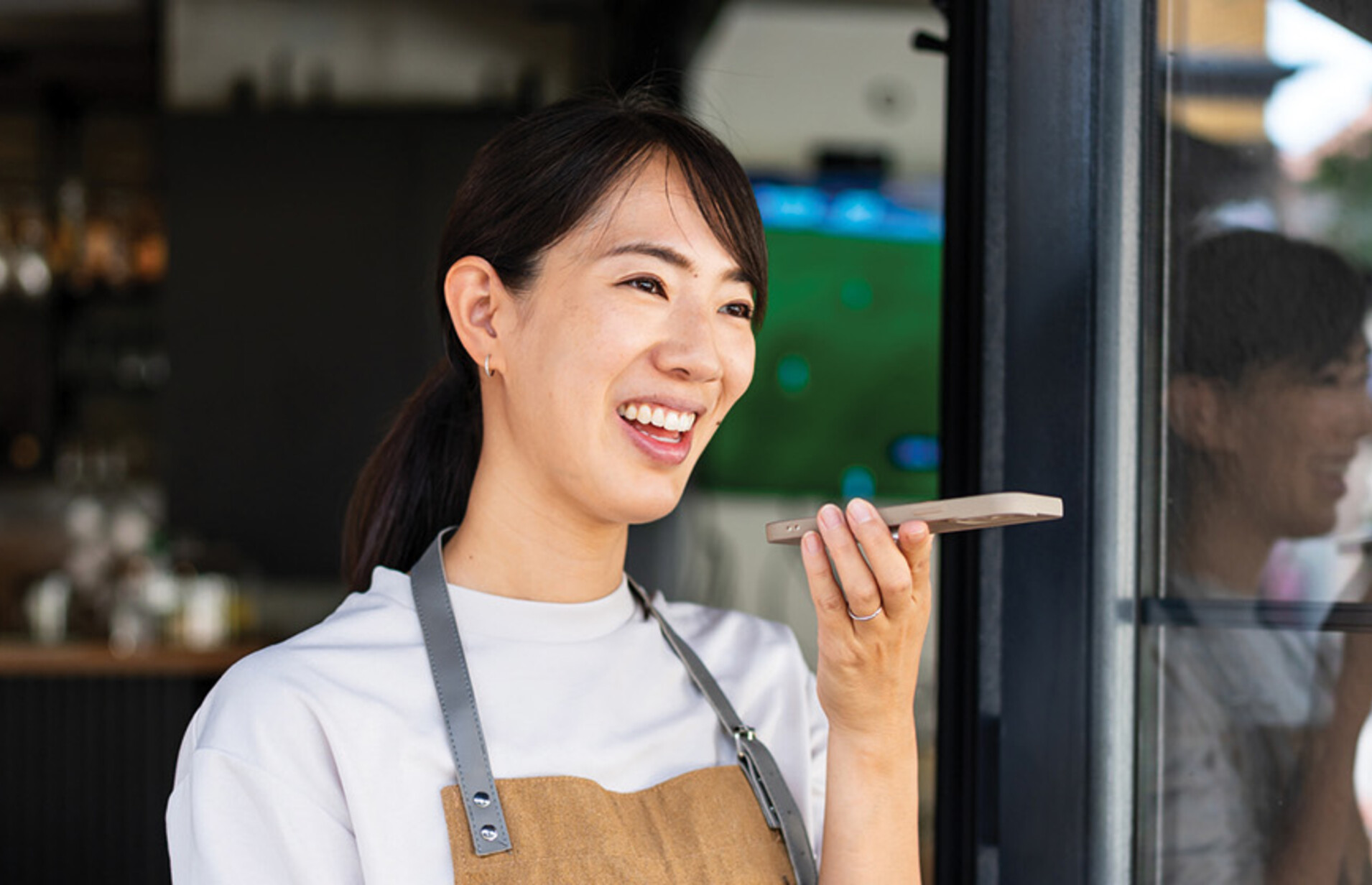 Woman uses phone voice command in cafe
