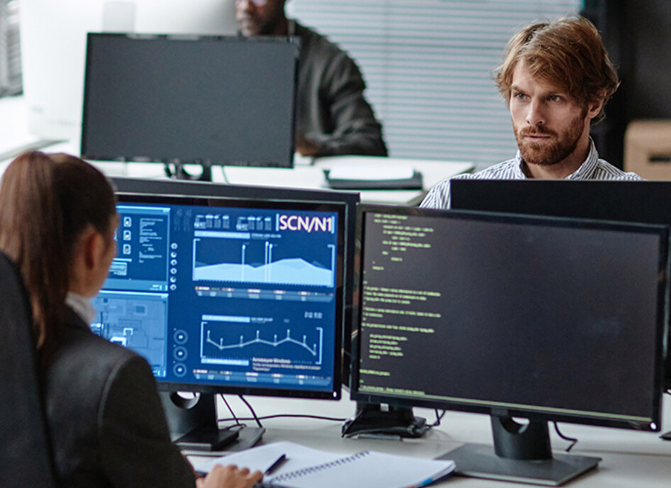 Young IT Developers Working with Multiple Computers