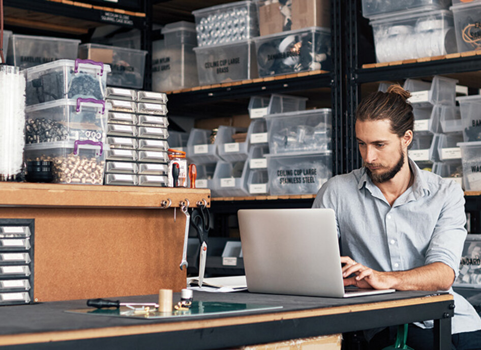 small business owner does inventory on his laptop