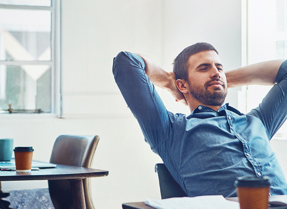 An employee leans back at his desk