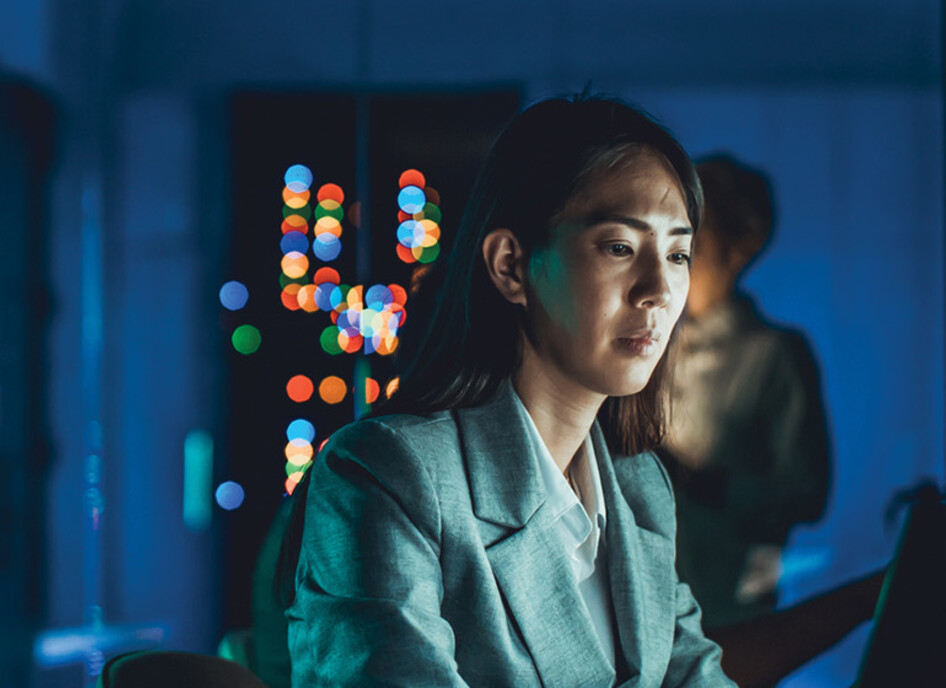 IT specialist working on a laptop in low lighting