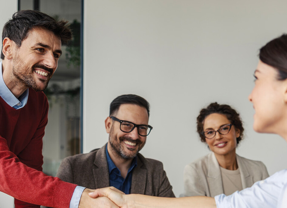 Colleagues shaking hands in an office business meeting
