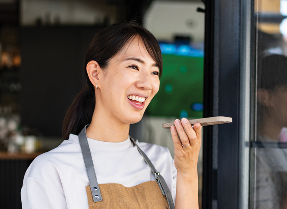 Woman uses phone voice command in cafe